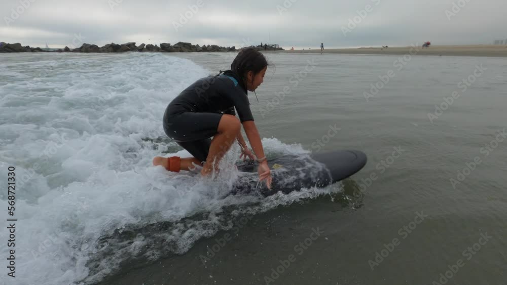 Young girl surfing during a cloudy day in Venice beach. Young girl surfing during a cloudy day in Venice beach.