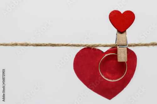 Golden ring hanging on a clothespin with a heart