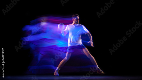 Power. Young man  professional handball player in motion  playing over black background with mixed lights effect. Concept of sport  action  motion  competition  championship  sportive lifestyle