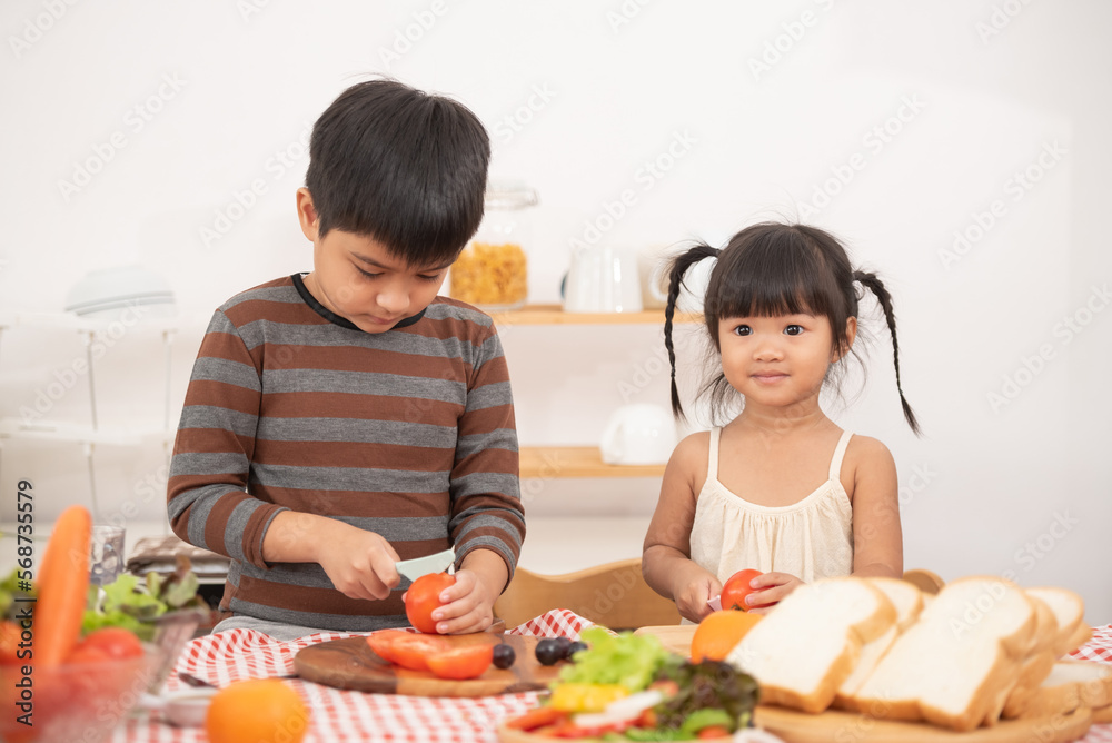 Happy children prepares and eats vegetable salad in kitchen. The concept of healthy diet and lifestyle. Vegan food and healthy lifestyle.Selective Focus. Happy children prepares and eats vegetable salad in kitchen. The concept of healthy diet and lifestyle. Vegan food and healthy lifestyle.Selective Focus.