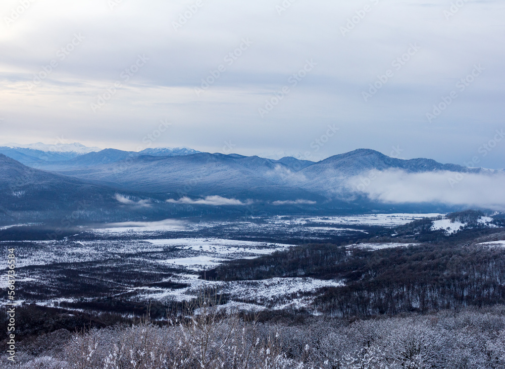 A winter morning in a mountainous area, a panorama of snow-capped mountains, slopes in a snowy decoration.