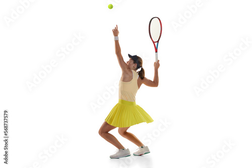 Dynamic portrait of young teen girl, tennis player in sports uniform in action, motion isolated over white background. Concept of sport, fashion, motivation, education and achievement