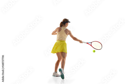 Dynamic portrait of young teen girl, tennis player in sports uniform in action, motion isolated over white background. Concept of sport, fashion, motivation, education and achievement © Lustre