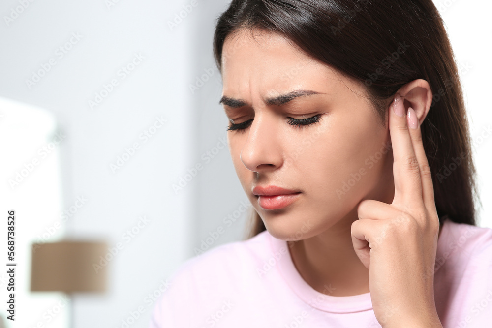 Young woman suffering from ear pain indoors, closeup. Space for text Young woman suffering from ear pain indoors, closeup. Space for text