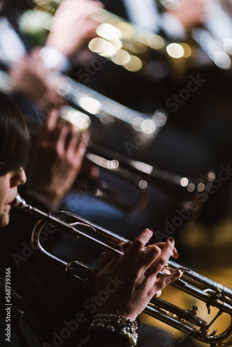 Trumpeters of a marching band in a row play during a concert in the theater
