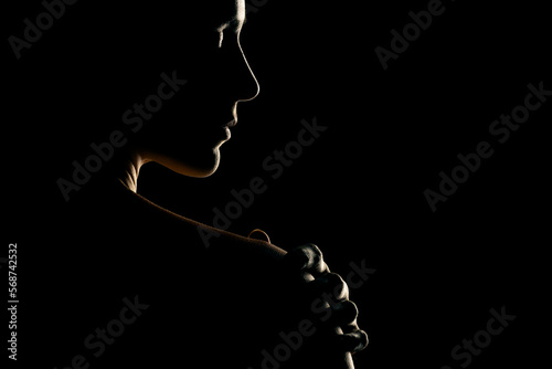 Sensual portrait silhouette of beautiful woman in backlight on a black background photo