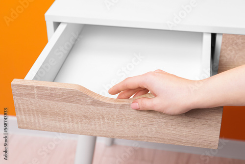 Woman opening empty desk drawer indoors  closeup