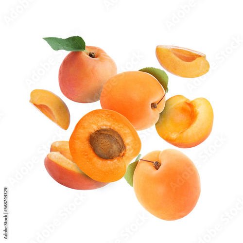 Delicious ripe sweet apricots falling on white background