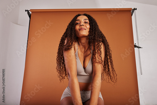 Young black with woman posing in underwear on an orange backdrop photo