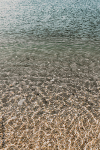 Pure clear transparent calm water surface background of sea or ocean with sandy bottom for wallpapers. Traveling to south. Spending summer vacations in warm mild climate. No people