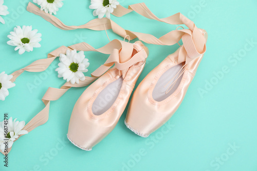 Ballet shoes. Elegant pointes and flowers on turquoise background, flat lay