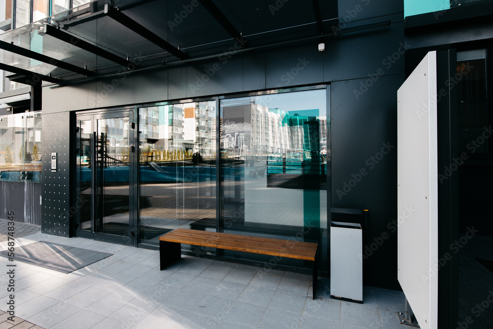 entrance to the lobby of a modern apartment building with glass doors and mailboxes