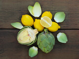 Artichokes and lemons on wooden table, flat lay