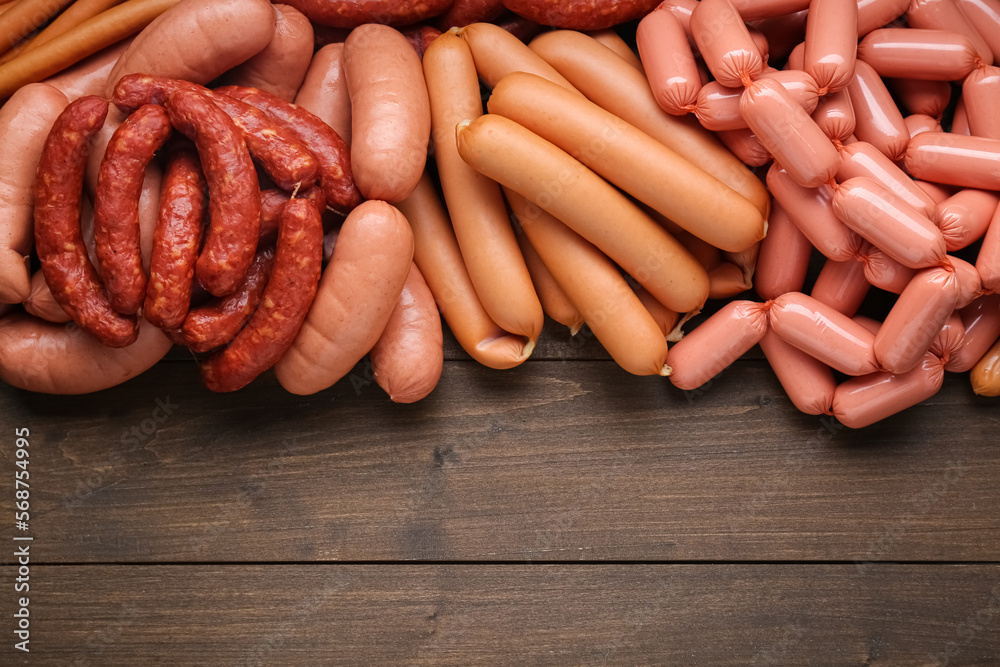 Different delicious sausages on wooden table, flat lay. Space for text