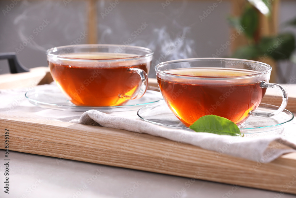 Aromatic hot tea in glass cups on light grey table indoors, closeup Aromatic hot tea in glass cups on light grey table indoors, closeup