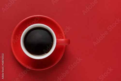 Cup with aromatic coffee on red background  top view. Space for text