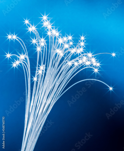 Fototapeta Naklejka Na Ścianę i Meble -  Bundle of optical fibers with lights in the ends. Blue background.