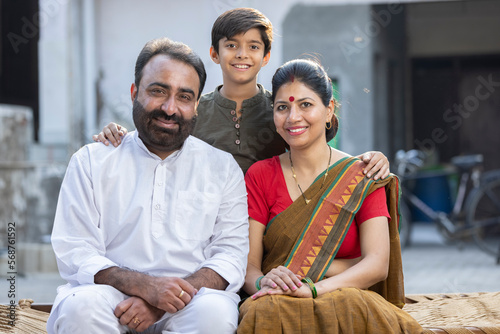 Photography Happy rural family sitting on traditional bed at village
