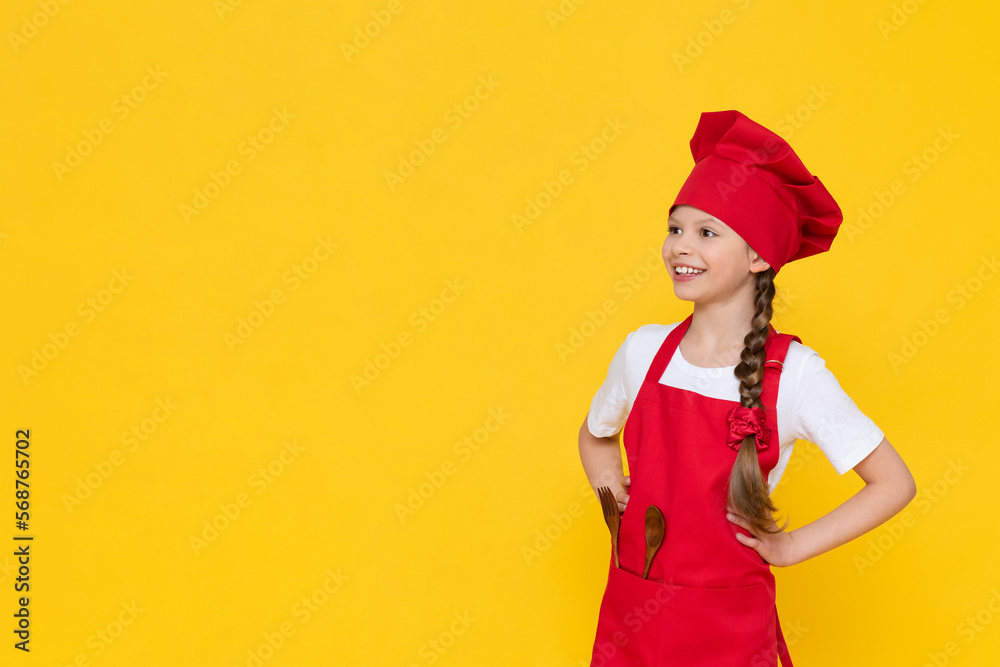 A little girl in a cook's costume, a baby cook breakfast in a chef's costume. The concept of cooking lunch, a girl cook on a yellow isolated background with copy space. A little girl in a cook's costume, a baby cook breakfast in a chef's costume. The concept of cooking lunch, a girl cook on a yellow isolated background with copy space.