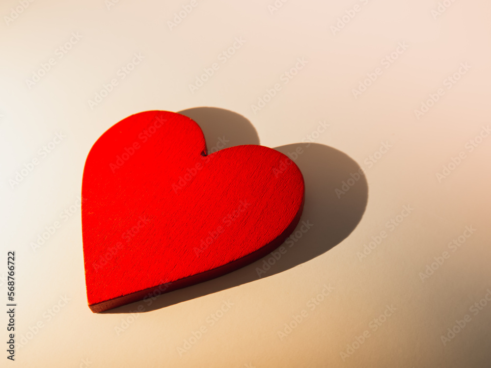 Valentine's Day. Red wooden heart concept on light background with heart shadow Valentine's Day. Red wooden heart concept on light background with heart shadow