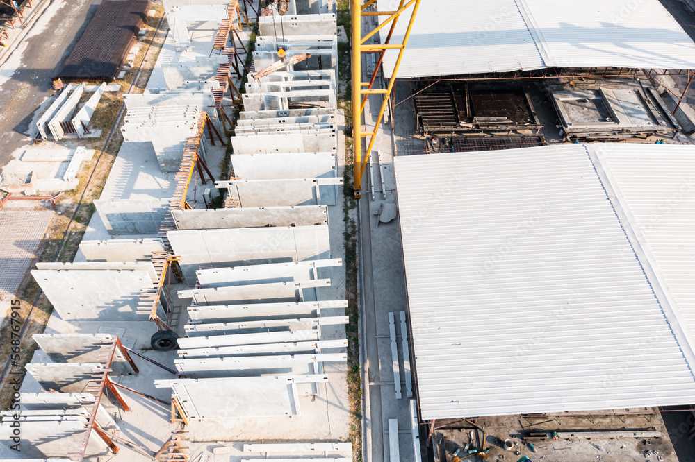 Aerial top view of Precast concrete wall panel for construction building site in warehouse factory. Precast concrete manufacturing products on prefabricated house factory Aerial top view of Precast concrete wall panel for construction building site in warehouse factory. Precast concrete manufacturing products on prefabricated house factory