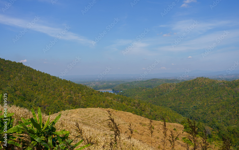 green and brown mountain landscape stacked together The sky is clear with streaks of clouds. green and brown mountain landscape stacked together The sky is clear with streaks of clouds.