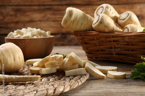 Whole and cut parsnips on wooden table