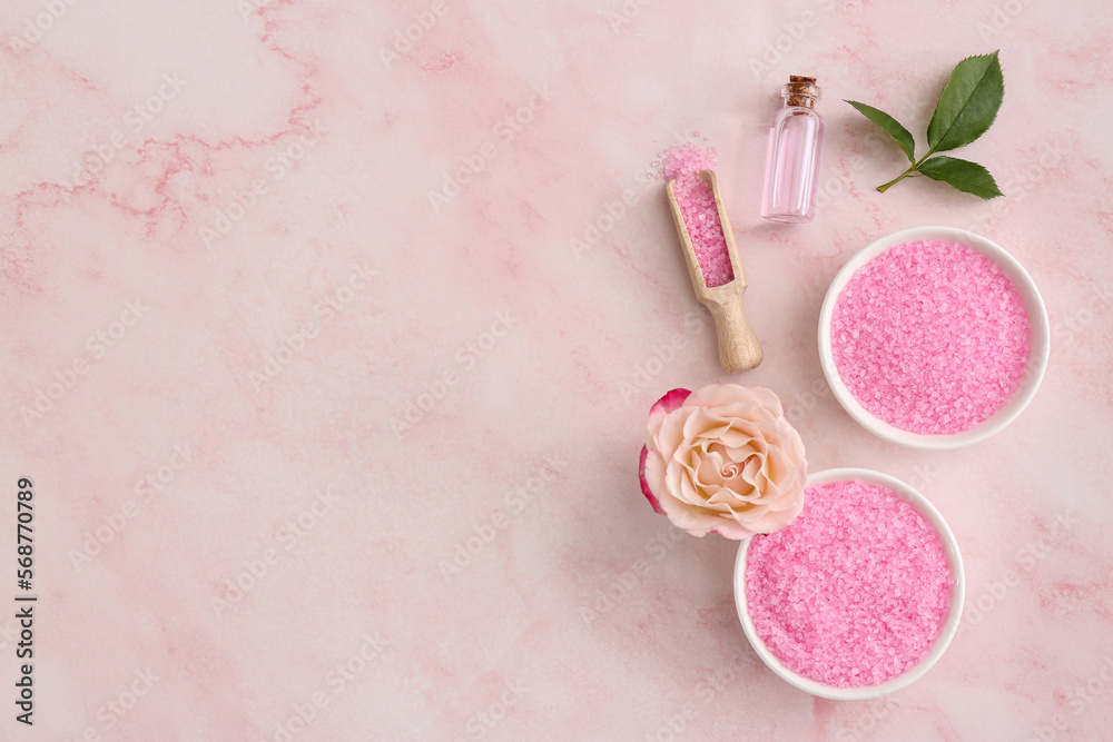 Bowls and scoop with sea salt, beautiful rose on pink marble table, flat lay. Space for text Bowls and scoop with sea salt, beautiful rose on pink marble table, flat lay. Space for text