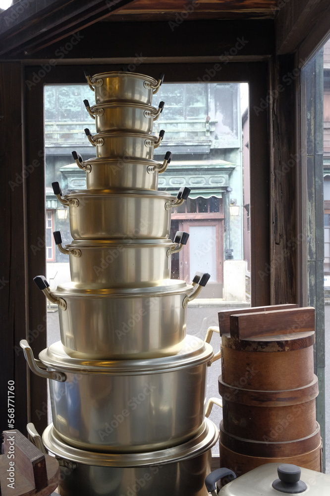 Naklejka premium アルマイト鍋がスタッキングされた、昭和レトロな荒物屋（家庭用雑貨点）の店頭ウィンドウ