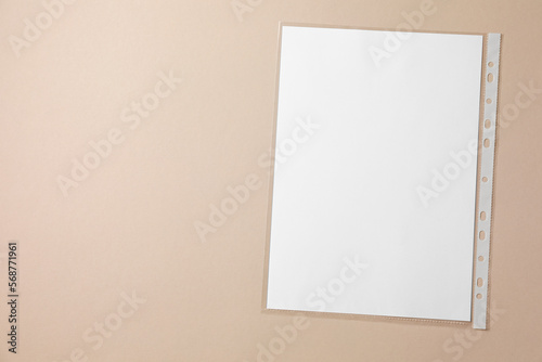Punched pocket with paper sheet on light grey background, top view. Space for text