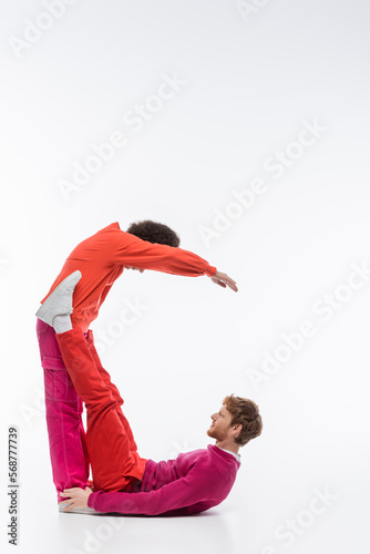 interracial couple in magenta color clothes showing c letter on white background.