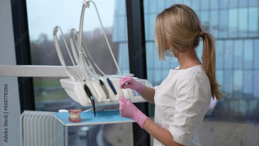 Dentist using drill getting it ready for dental surgery intervention Dentist using drill getting it ready for dental surgery intervention