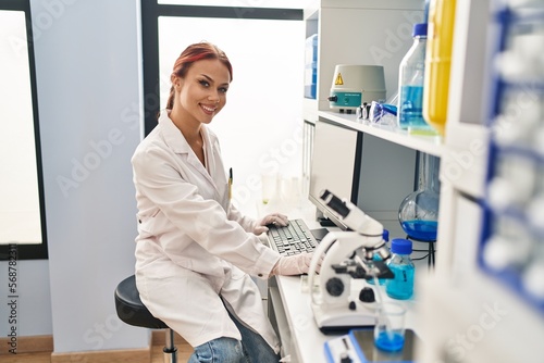 Young caucasian woman scientist using computer at laboratory