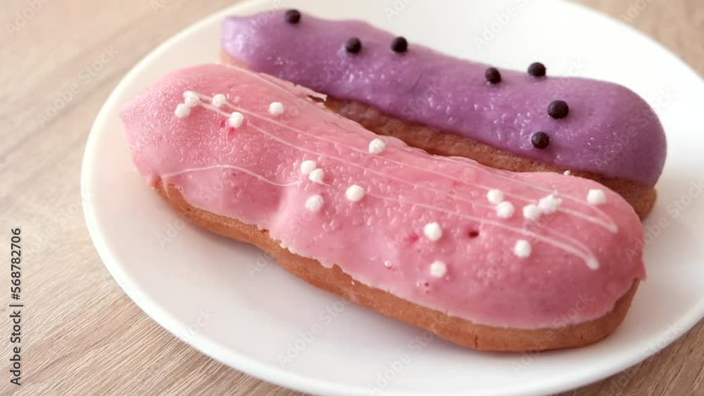 sweets on a white plate. colored eclairs in chocolate icing sweets on a white plate. colored eclairs in chocolate icing