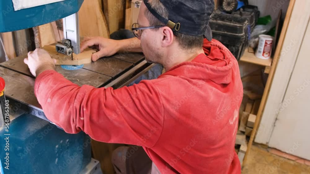 Close-up of a carpenter's hands working on a band saw with a wooden mold to create interior items Close-up of a carpenter's hands working on a band saw with a wooden mold to create interior items
