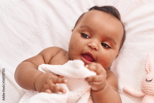 African american baby lying on bed at bedroom