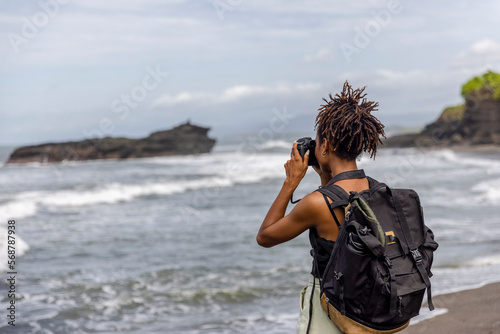 Indonesia, Bali, Female tourist photographing sea view