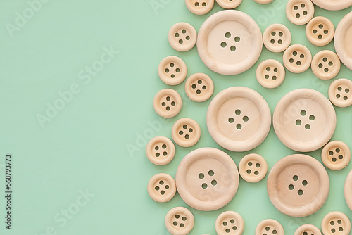 Wooden buttons on a green background. layout for creativity and hobbies. Wooden button