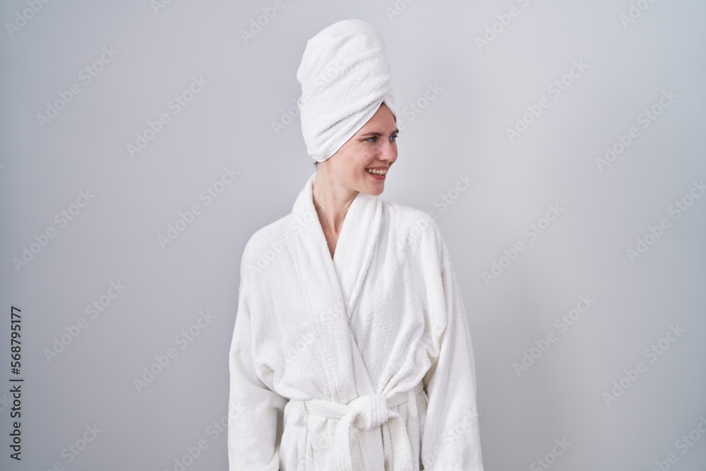 Blonde caucasian woman wearing bathrobe looking away to side with smile on face, natural expression. laughing confident. Blonde caucasian woman wearing bathrobe looking away to side with smile on face, natural expression. laughing confident.