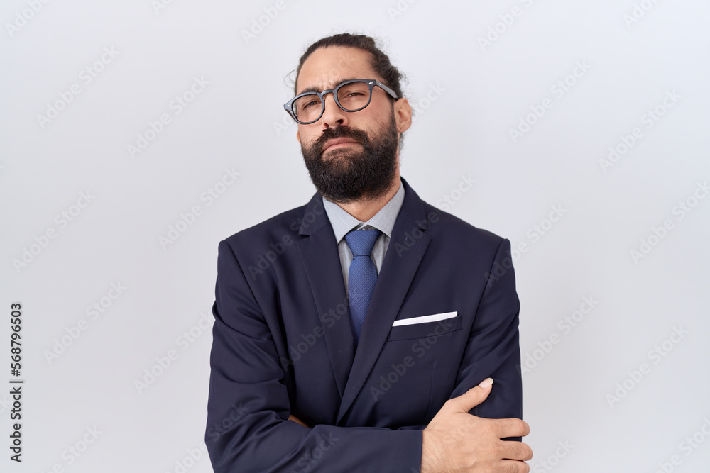 Hispanic man with beard wearing suit and tie skeptic and nervous, disapproving expression on face with crossed arms. negative person. Hispanic man with beard wearing suit and tie skeptic and nervous, disapproving expression on face with crossed arms. negative person.