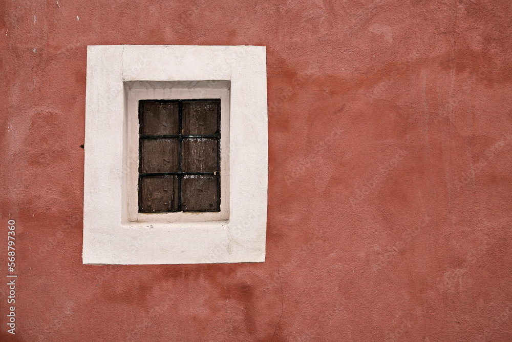 Small Spanish window with off-white surround and ochre coloured wall