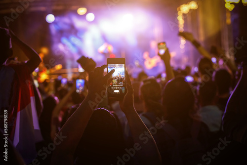 Large group of happy people enjoying rock concert.