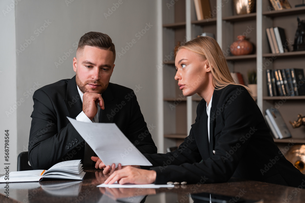 Pensive business people studying office papers and notes Pensive business people studying office papers and notes