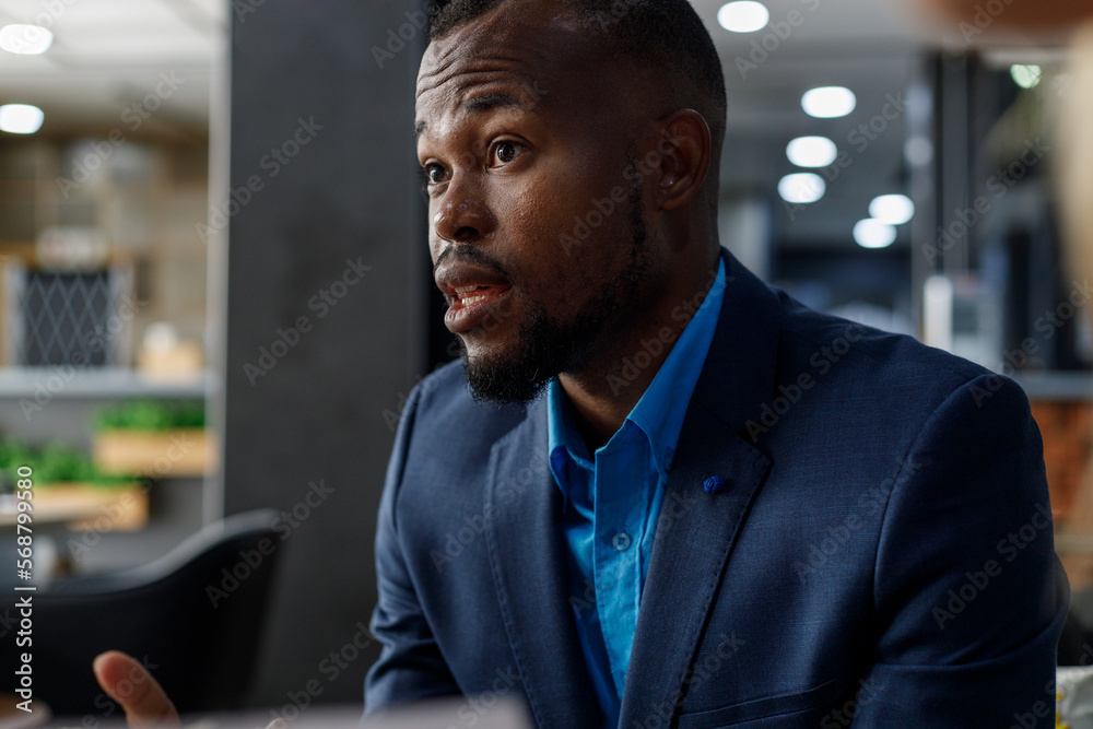 Naklejka premium Businessman listening and looking at partner in meeting