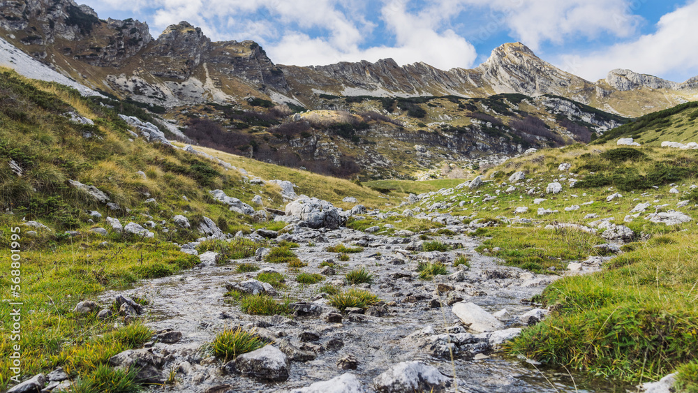 Fototapeta premium Mountain stream in good weather. Mountain landscape and sky with clouds