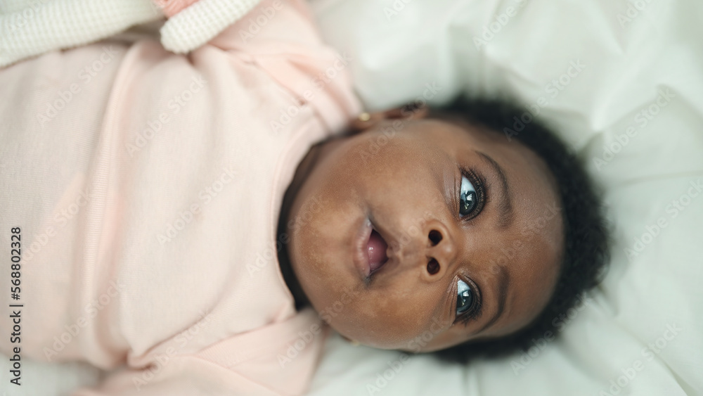 African american baby lying on bed with relaxed expression at bedroom African american baby lying on bed with relaxed expression at bedroom