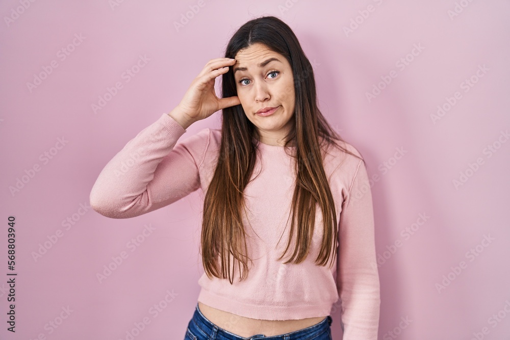 Young brunette woman standing over pink background worried and stressed about a problem with hand on forehead, nervous and anxious for crisis Young brunette woman standing over pink background worried and stressed about a problem with hand on forehead, nervous and anxious for crisis