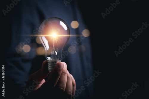 businessman hold light bulb inspired by innovative business idea, male boss or director motivated with successful startup in office, innovation, energy save concept.