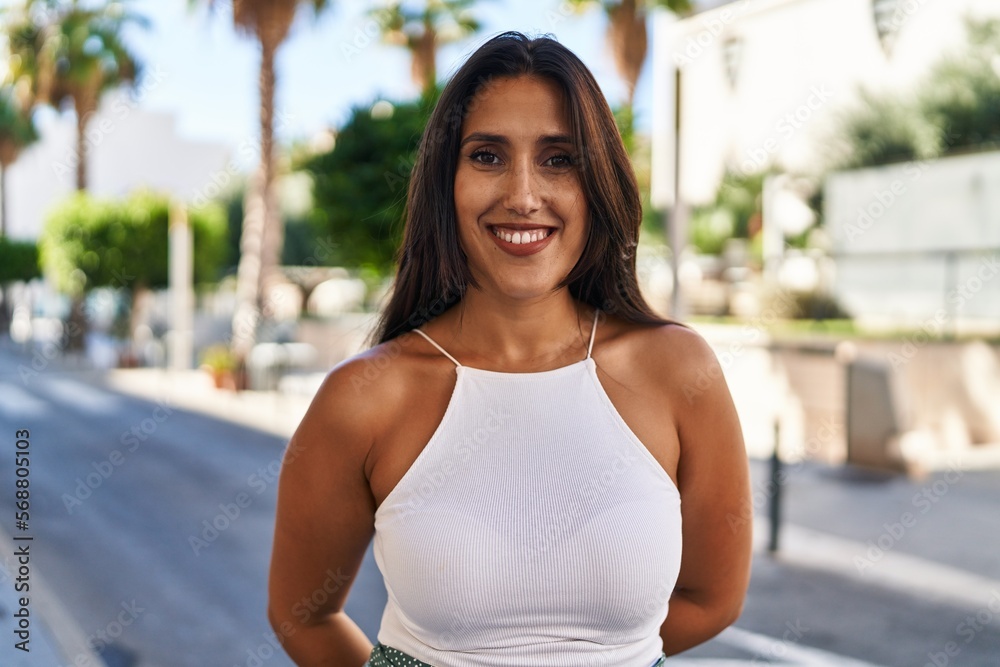 Young hispanic woman smiling confident walking at street