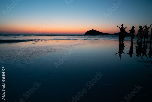 夕暮れの浜辺　若者たちのシルエット © @HY
